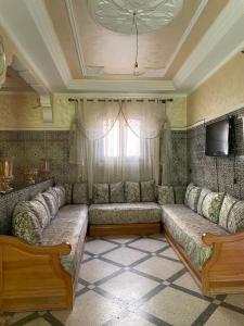 a living room with a couch and a tv at Appartement in Benguerir