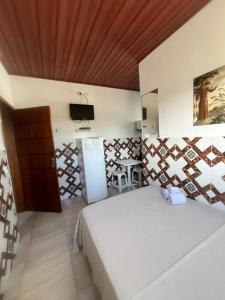 a bedroom with a bed and a tv and a table at Pousada Pesque Park in Boracéia