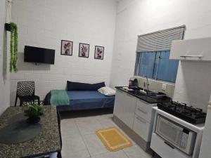 a small room with a bed and a kitchen at Casa Completa e Confortável em Cotia in Cotia