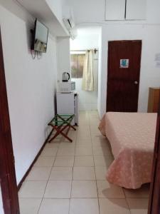 a room with a bed and a tv on a wall at Brisas Del Rio Apart Hotel in Termas del Daymán