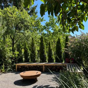 a wooden bench sitting in the middle of a garden at Garden 52 in Šutovce