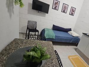 a living room with a bed and a table at Casa Completa e Confortável em Cotia in Cotia