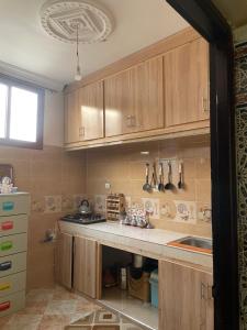 a kitchen with wooden cabinets and a sink at Appartement in Benguerir