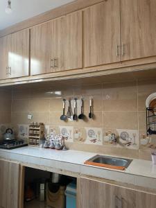 a kitchen with wooden cabinets and a sink and utensils at Appartement in Benguerir +34 photos