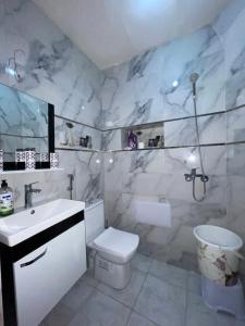 a bathroom with a white toilet and a sink at Appartement in Benguerir