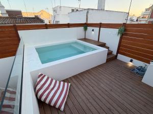a hot tub on a deck with a pillow at AL do Barão - Casa de Charme com Piscina Privada in Vila Real de Santo António