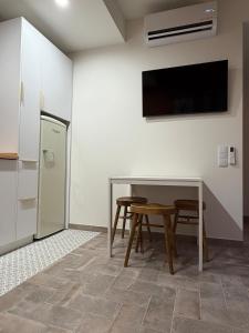 a kitchen with a table and a tv on a wall at AL do Barão - Casa de Charme com Piscina Privada in Vila Real de Santo António