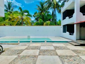 a villa with a swimming pool and palm trees at Costa Ayala - Suites & Bungalows in Los Ayala