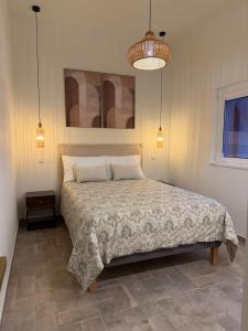 a bedroom with a large bed with two pillows at AL do Barão - Casa de Charme com Piscina Privada in Vila Real de Santo António +18 photos