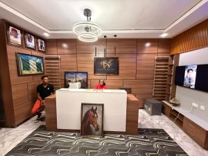 two people standing at a reception desk in a hotel lobby at Mario Suites Ltd in Kano