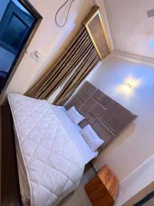 a small bedroom with a bed and a window at Mario Suites Ltd in Kano