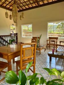 a living room with a wooden table and chairs at Pousada Canto do Luar in Conceição do Mato Dentro +45 photos