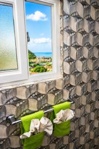 a bathroom with a stone wall and two windows at Piton Views & Sunset Balcony, Minutes to Beaches in Soufrière