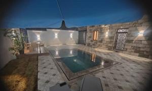 a swimming pool in the middle of a house at Villa zahra 7 in Kêf Bisnês