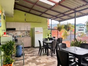 a restaurant with tables and chairs and a kitchen at Hotel Casa Verde Guatapé in Guatapé