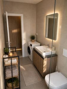 a bathroom with a sink and a washing machine at Apartman PEPI LUXURY in Novi Zagreb +6 photos