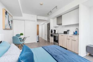 a living room with a couch and a kitchen at Executive Studio w Balcony Steps to Eaton Centre in Toronto
