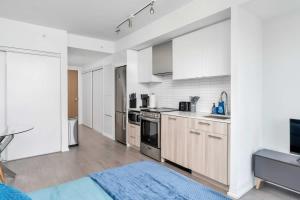 a kitchen with white cabinets and a blue rug at Executive Studio w Balcony Steps to Eaton Centre in Toronto