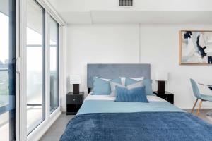 a bedroom with a large bed with blue pillows at Executive Studio w Balcony Steps to Eaton Centre in Toronto +13 photos