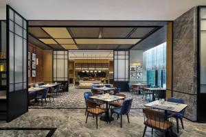 a restaurant with tables and chairs and a bar at Four Points by Sheraton Linyi Hedong in Linyi