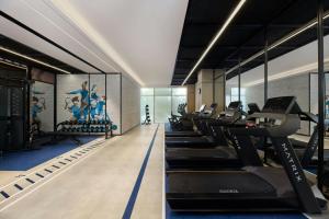 a gym with a row of treadmills and ellipticals at Four Points by Sheraton Linyi Hedong in Linyi