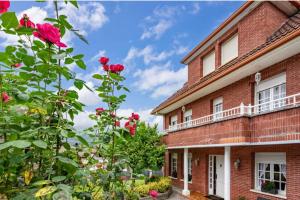 a red brick building with roses in front of it at CASAMENTERA in Mentera-Barruelo