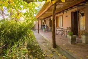 a porch of a house with a table and chairs at GuardiaPiemontese Aparts in Capilla del Monte