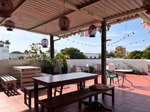 a patio with tables and benches on a roof at Hostal Casa Lulú Santa Marta in Santa Marta