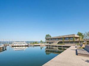 a marina with a building and boats in the water at Guesthouse Spa Seeblick in Breitenbrunn