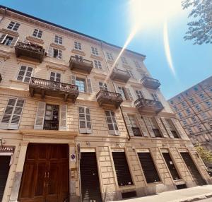 a large building with windows and doors on a street at Top Rooms Torino in Turin