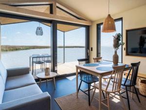 a living room with a couch and a table and chairs at Guesthouse Spa Seeblick in Breitenbrunn