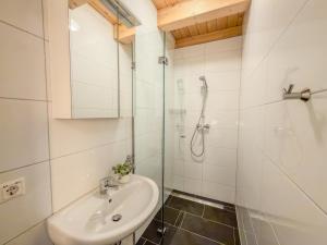 a white bathroom with a sink and a shower at Kipaji 2 in Kötschach