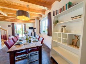 a dining room with a wooden table and red chairs at Kipaji 2 in Kötschach +34 photos