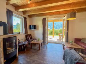 a living room with a fireplace and a large window at Kipaji 3 in Kötschach