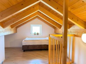 a attic bedroom with a bed and a window at Kipaji 3 in Kötschach