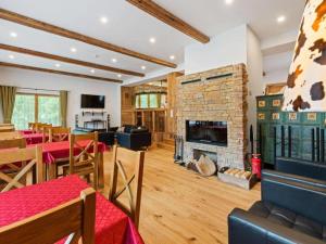 a living room with a fireplace and a dining room at Haus Planegg XL in Rangersdorf