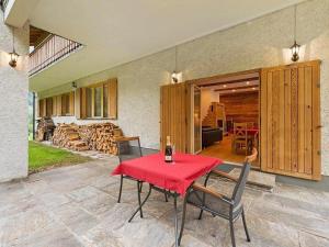 a patio with a red table and chairs and a room at Haus Planegg XL in Rangersdorf