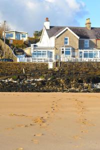 a house on the shore of a beach at Sea View Guest House in Benllech