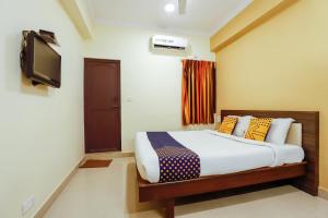 a bedroom with a bed and a television in it at SPOT ON Central Inn in Chennai