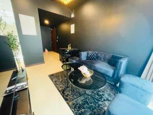 a living room with a blue couch and a table at Colombo Trizen Nuva Apartments in Colombo