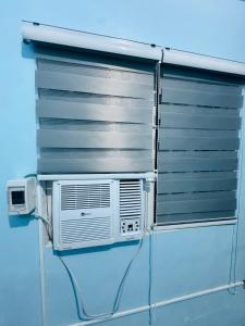 a window with a air conditioner on a wall at MiKasa Azul Transient House in Cabuyao