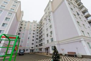 a christmas tree in front of a large building at Luna Minimalist Apartment in Chişinău