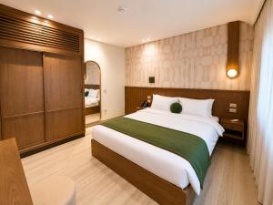a bedroom with a large bed with a green blanket at NOMA New Cairo in New cairo