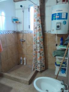a bathroom with a shower and a tub and a sink at Quinta Doña Delia in Agote