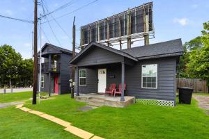 a small house with two red chairs in the yard at Cozy Heights 2 BD Bungalow, Walkable in Houston