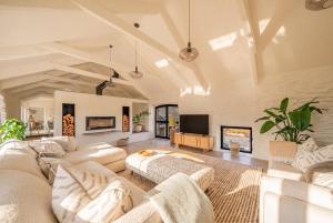 a living room with white furniture and a flat screen tv at Treloggas Retreat in Truro