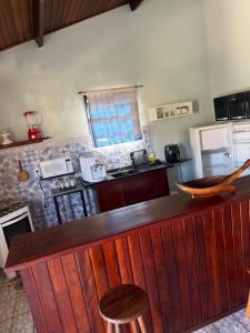 a kitchen with a wooden bar with a counter top at APARTAMENTO SIMPLES E ACONCHEGANTE in Paraty