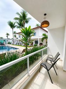 a balcony with a view of the pool and palm trees at Makai Hotel Boutique - Frente Mar in Guarujá