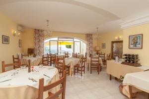 a restaurant with tables and chairs and a large window at Hotel Ape Regina in Casamicciola Terme