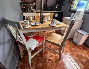 a table and chairs with cups and plates on it at Los boldos in Concón